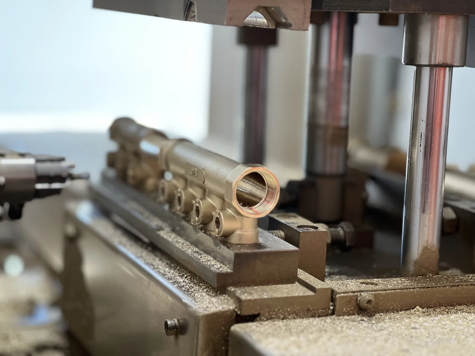 Brass underfloor heating manifold body being turned from solid bar on a CNC machining line