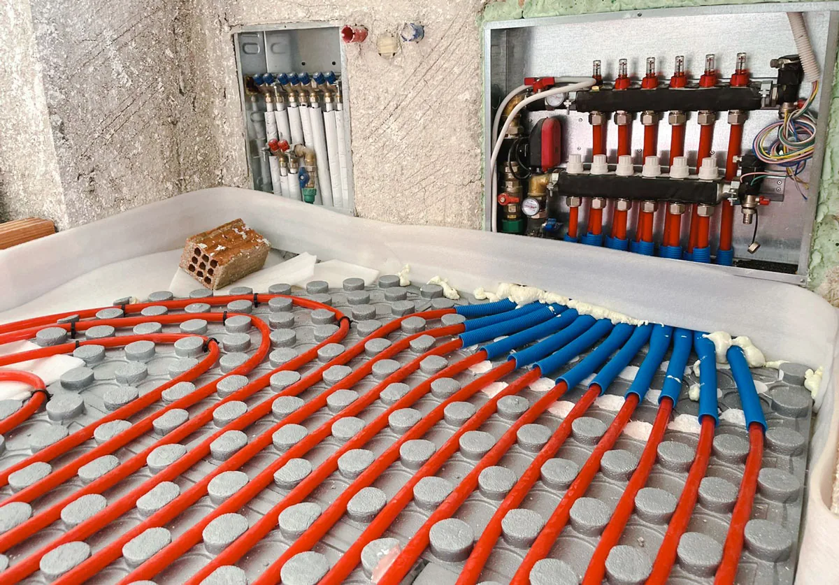 PEX pipe for underfloor heating being clipped into loops on insulation before the screed pour